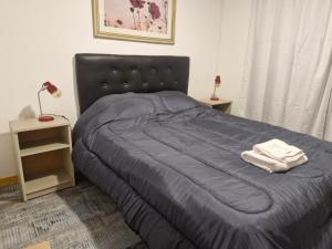 una camera da letto con un letto con una coperta blu e due lampade di Lugar de Descanso Azul ad Azul