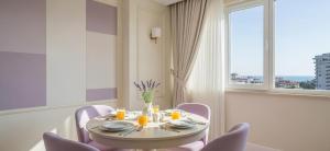 een eetkamer met een tafel en stoelen en een raam bij Lilac Apart 1 Antalya in Antalya +14 foto's