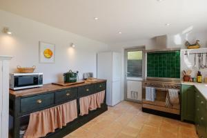 a kitchen with a counter with a microwave and a stove at Greengates Nature Filled Countryside Escape 