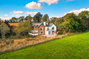 a house on a hill with a green field at Greengates Nature Filled Countryside Escape 