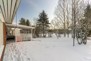 a yard covered in snow next to a house at Rovaniemi Spacious Lapland Vacation Home with Private Sauna & Lappish Fire Hut in Rovaniemi