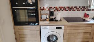 eine Küche mit einer Waschmaschine in der Unterkunft Maison game in Villeneuve-sous-Dammartin