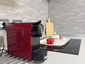 una macchina per il caffè rossa su un bancone con un tavolo di Hulin guesthouse a Roma
