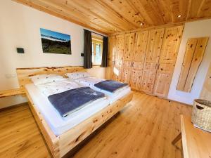 a large bed in a room with wooden floors at Ferienhaus Bergmann in Bad Aussee