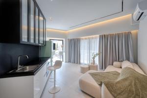 World Luxury Suites Trikala في تريكالا: مطبخ وغرفة معيشة مع أريكة ومغسلة