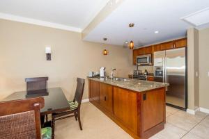 a kitchen with a counter top and a refrigerator at Honua Kai 1024 · HK 1024 Updated Beachfront Luxury Condo w Pool in Lahaina