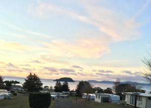 a view of the ocean from a campground at sunset at Motutere Bay TOP 10 Holiday Park in Turangi