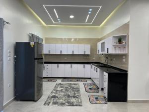 a kitchen with white cabinets and a black refrigerator at Twins Villa Luxor in Luxor