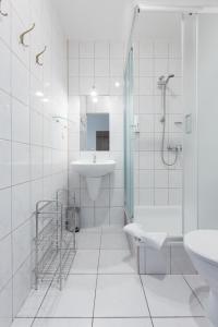 a white bathroom with a shower and a sink at HOTEL ŁABĘDY i Hostel Łabędy in Gliwice