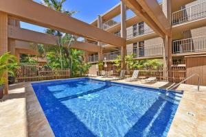 a swimming pool in front of a building at Kaleialoha 402 · KA 402 Spacious Studio Close to Ocean Heated Po in Kahana