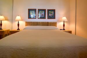 Un dormitorio con una gran cama blanca con dos lámparas. en Napili Point A8 · NP A8 OceanFront 1BD Condo w Ocean Views AC Po, en Kahana 42 fotos más