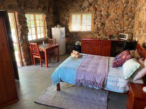 a bedroom with a bed and a kitchen with a table at Rondeberg Holiday Resort in Clanwilliam