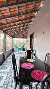Ein schwarzer Tisch und Stühle auf einer Terrasse mit rosa Blumen in der Unterkunft Recanto da Rosa in Santarém