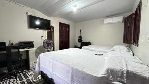 ein Schlafzimmer mit einem Bett und einem Flachbildfernseher in der Unterkunft Recanto da Rosa in Santarém