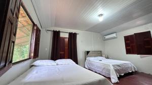 zwei Betten in einem Zimmer mit Fenster in der Unterkunft Recanto da Rosa in Santarém