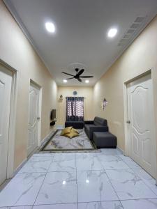 Una sala de estar con un sofá y un ventilador de techo. en Echah's Homestay-mslim only, en Jeram