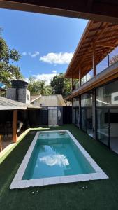 ein Swimmingpool mitten in einem Haus in der Unterkunft CasadevidroTTP Pé na areia in São Sebastião
