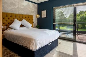 a bedroom with a large bed with a large window at Nor67 - Witley Park House in Little Witley