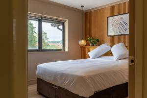 a bedroom with a large bed and a window at Nor67 - Witley Park House in Little Witley +13 photos