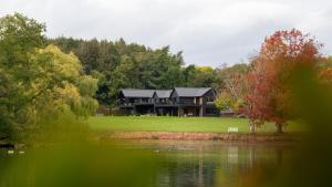 a large house with a lake in front of it at Nor67 - Witley Park House in Little Witley