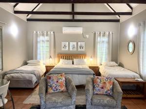a bedroom with two beds and two chairs at Rondeberg Holiday Resort in Clanwilliam +162 photos