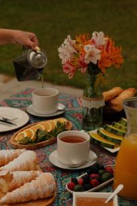 ein Tisch mit Tassen Tee und Tellern mit Essen in der Unterkunft Zhebota garden Tianeti in Zhebota