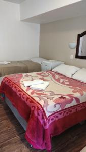 a bed in a room with a blanket on it at Recanto da Ladeira in Gramado