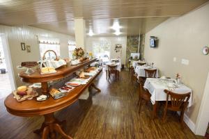 a restaurant with tables and chairs with food on display at Recanto da Ladeira in Gramado