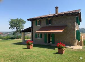 a house with two flower pots in front of it at Casale IL SAMBUCO sui colli bolognesi in San Lazzaro di Savena