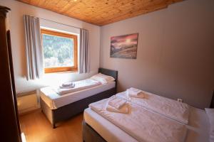 a small room with two beds and a window at Chalet Gondelblick in Zell am See