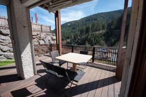 a table and chairs on a deck with a view of a mountain at Chalet Gondelblick in Zell am See