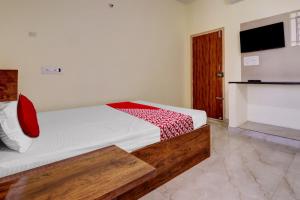 a bedroom with a bed with a red blanket on it at Collection O Preethi Boarding & Lodging in Kammasandra