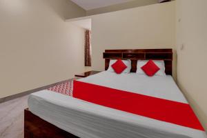 a bedroom with a large bed with red pillows at Collection O Preethi Boarding & Lodging in Kammasandra +22 photos