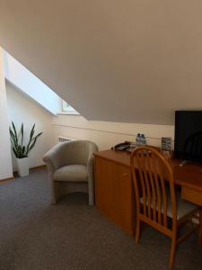 a room with a desk and a chair and a computer at Hotel Dana in Bytów
