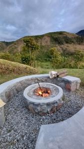 een vuurplaats in het grind met een heuvel op de achtergrond bij Domo Gran Vista 28A 