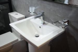 a bathroom with a white sink and a toilet at First House Mihintale in Mihintale