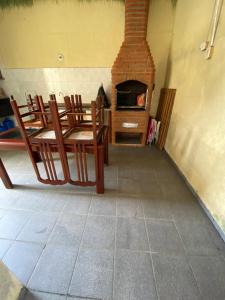 ein Wohnzimmer mit Stühlen und einem gemauerten Kamin in der Unterkunft Casa de praia peruibe in Peruíbe