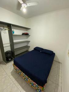 ein Schlafzimmer mit einem blauen Bett in einem Zimmer in der Unterkunft Casa de praia peruibe in Peruíbe + 4 Fotos
