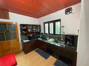 a kitchen with a sink and a counter top at Temple Courtyard in Chengannūr