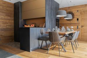 une salle à manger avec une table et des chaises dans l'établissement KitzSki Luxury Apartment ski-in ski-out accommodation, à Mittersill