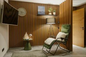 une chambre avec une chaise et un réveil sur un mur dans l'établissement KitzSki Luxury Apartment ski-in ski-out accommodation, à Mittersill