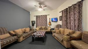 a living room with couches and a ceiling fan at Cliff Hostel in Amman