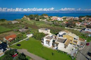 eine Luftaufnahme eines Hauses mit dem Meer im Hintergrund in der Unterkunft Kamarina Apartments in Peroulades