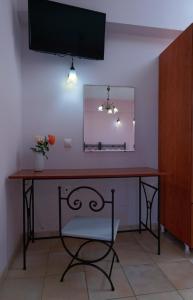 einen Schreibtisch mit einem Stuhl und einem Spiegel an der Wand in der Unterkunft Kamarina Apartments in Peroulades