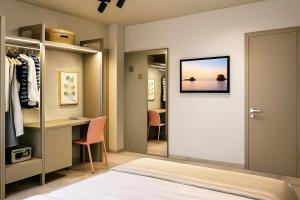 Un dormitorio con un escritorio y un vestidor. en Hotel Costa Azzurra, en Grado