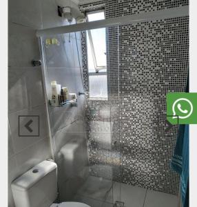 a bathroom with a toilet and a glass shower at Loft vista incrível beira mar continental in Florianópolis