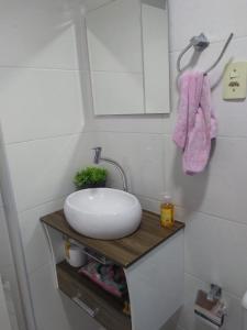 a bathroom with a white sink on a wooden counter at Loft vista incrível beira mar continental in Florianópolis +20 photos