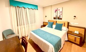 a hotel room with a bed and a chair at Hotel Spa Galatea in Burela de Cabo