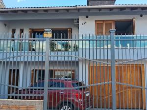 ein rotes Auto, das vor einem Haus parkt in der Unterkunft Kitnet Suíte Premium in Bento Gonçalves