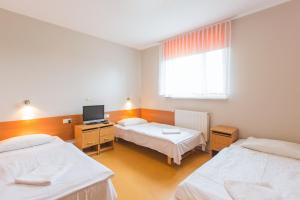 a hospital room with two beds and a television at HOTEL ŁABĘDY i Hostel Łabędy in Gliwice